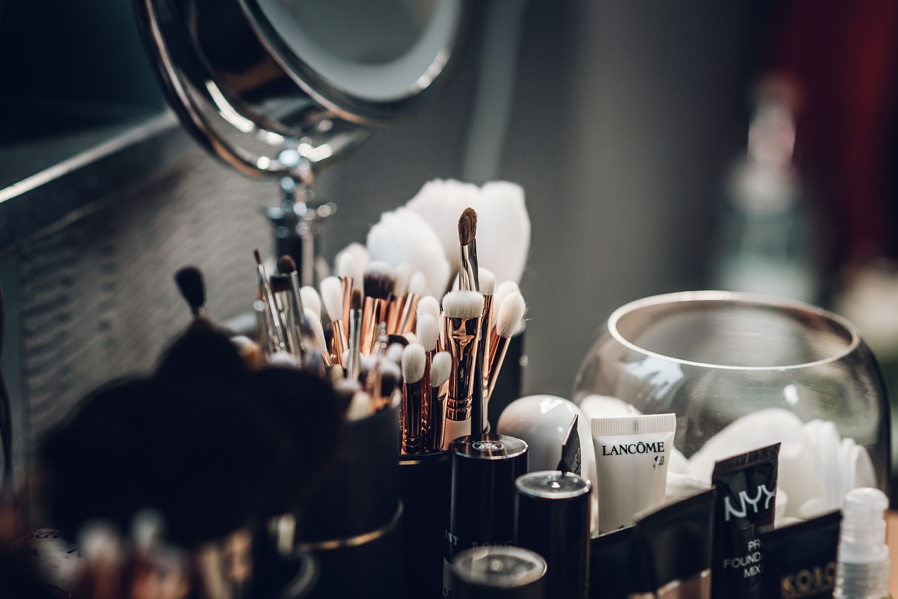 Make-up-Pinsel und Kosmetikprodukte auf einem Schminktisch mit Spiegel.