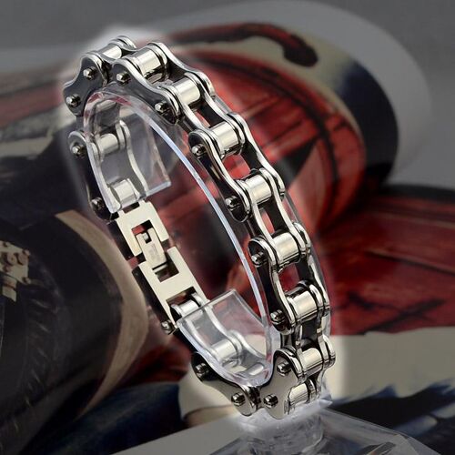 Silbernes Kettenglied-Armband auf transparentem Display vor offenem Magazin.