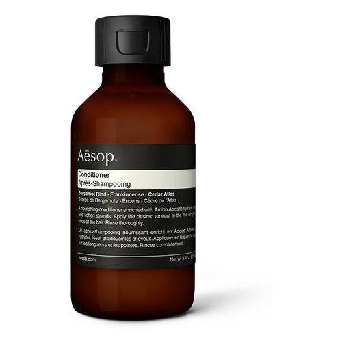 Braune Flasche Aesop Conditioner mit schwarzem Deckel auf weißem Hintergrund.