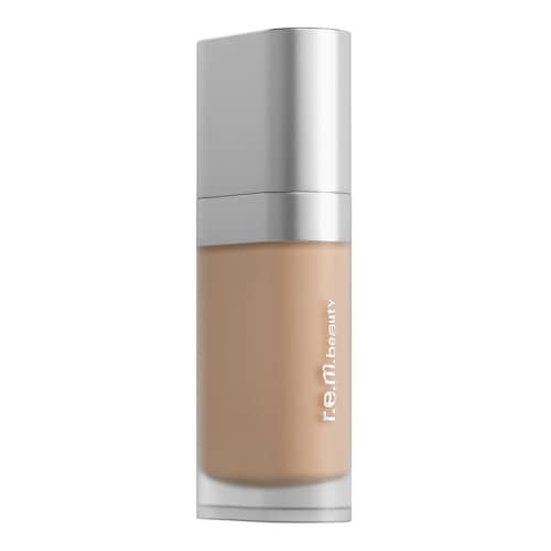 Eine Flasche flüssige Foundation mit silbernem Deckel und R.E.M. Beauty-Logo.