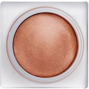 Runde Creme in goldener Farbe in einem quadratischen, transparenten Behälter.