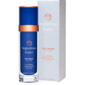 Blaue Cremeflasche mit orangem Deckel neben weißer Verpackungsbox.