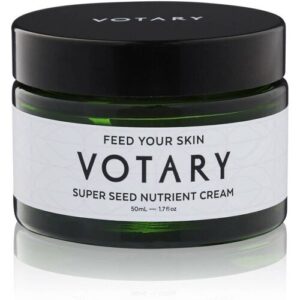 Grüner Glasbehälter mit schwarzem Deckel, beschriftet mit Votary Super Seed Nutrient Cream.