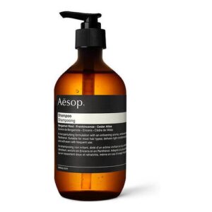Braune Shampoo-Pumpflasche von Aesop mit Etikett und schwarzem Spender.