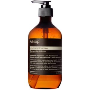 Braune Flasche mit Pumpspender und schwarzem Etikett für Volumen-Shampoo.