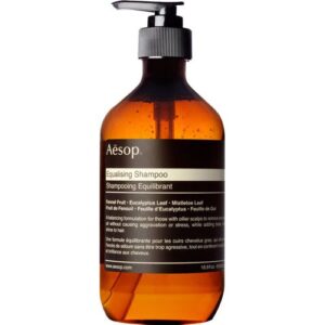 Braune Shampoo-Flasche mit schwarzem Pumpverschluss auf weißem Hintergrund.