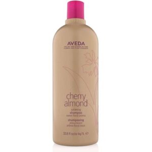 Beigefarbene Shampoo-Flasche mit rosa Deckel und Blumenmuster, Etikett mit "Cherry Almond".