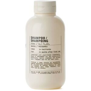 Weiße Shampooflasche mit Etikett für Basilikum- und Macadamia-Formel.